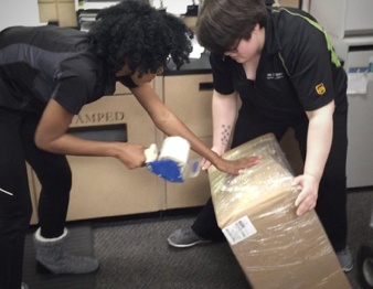 Female UPS workers taping box