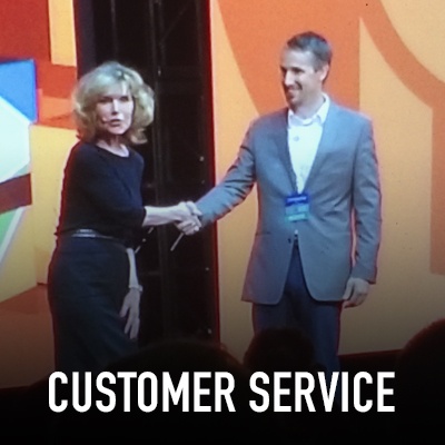 Vicki Hitzges on stage shaking hands with Customer Service title