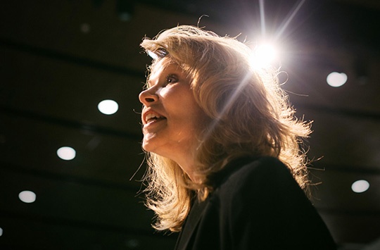 Keynote Speaker Vicki Hitzges low angle in auditorium with star light over her head