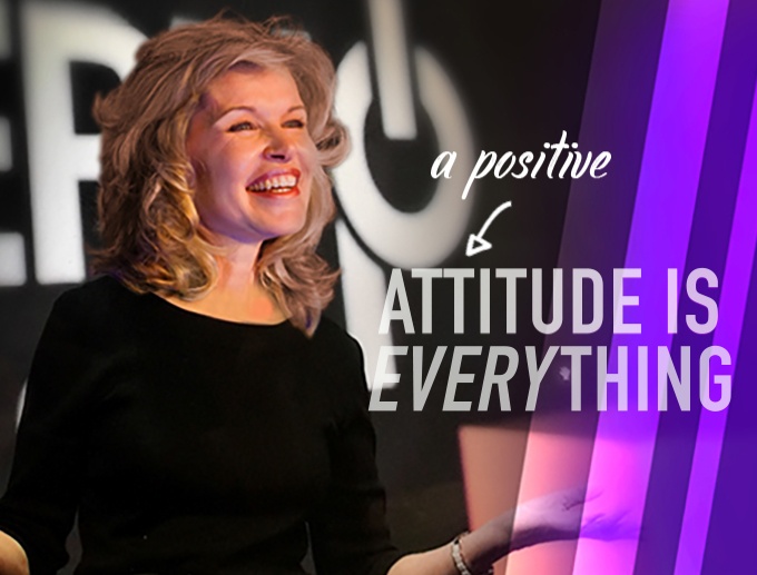 Keynote Speaker Vicki Hitzges on stage with A Positive Attitude is Everything text